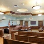 System Failure—Child Sent Across State Lines Empty courtroom with wooden benches and judge's bench