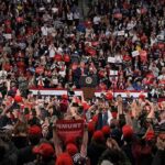 Election Oath Goes National: Thousands Swear To Vote Speaker at podium addressing large crowd in arena