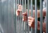 Federal Prisons Shift: Counseling, Not Hormones Hands gripping jail bars