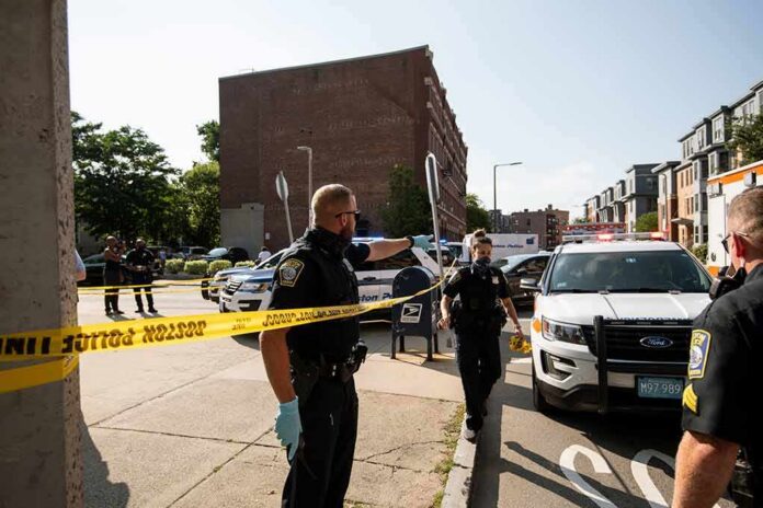 shutterstock_1781781026 Police officers secure an urban street with yellow tape near patrol cars