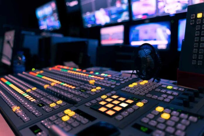broadcast control room mixing console with illuminated buttons