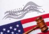 Gavel on U.S. flag beside official election mail envelope