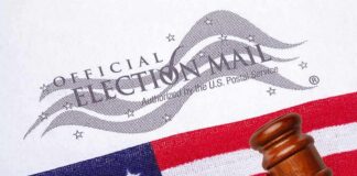 Gavel on U.S. flag beside official election mail envelope