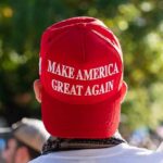 MAGA Muzzle? Bartiromo Out After Leak person wearing a red baseball cap at an outdoor gathering