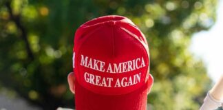 person wearing a red baseball cap at an outdoor gathering