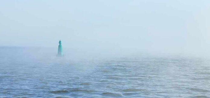 shutterstock_1870019050 Green buoy in foggy sea