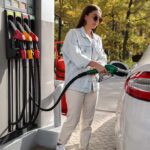 Woman refueling car at gas station pump