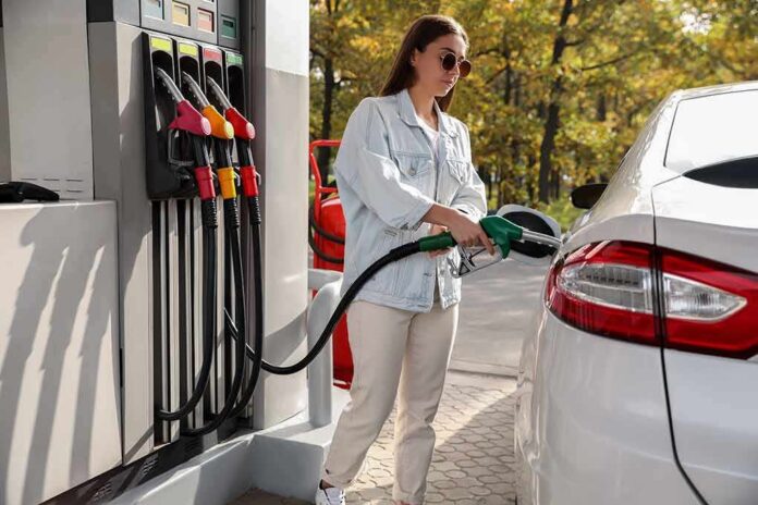 Woman refueling car at gas station pump