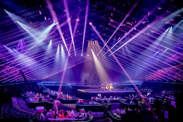 shutterstock_1982762090-1 Concert stage with performers under purple laser lights