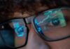 Tech Titans Tip S&P – Inflate A Ticking Risk Close-up of a persons eyes with financial data reflected in their glasses