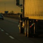 Newlyweds Dead – DMV Defends Undocumented Trucker Semi-truck trailer driving on highway at sunset