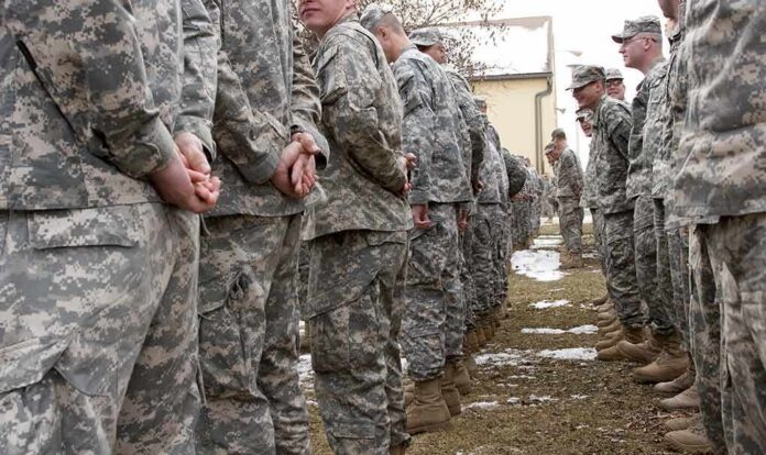 shutterstock_25208464 Soldiers in camouflage uniforms stand in two facing rows outdoors