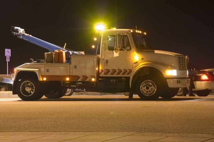 shutterstock_2638128 Tow truck with flashing lights parked at night