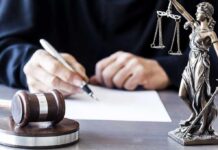Prosecutor Quits, Torches Chicago Boss Judge writing at desk with gavel and Lady Justice statue