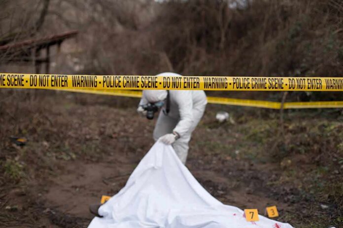shutterstock_792627700 forensic investigator at outdoor crime scene behind caution tape