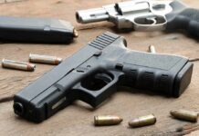 Handguns and ammunition on a wooden surface
