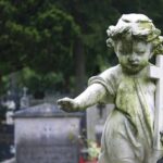 Grieve Abortion? Bereavement Leave For ‘Clump Of Cells’ Weathered statue of a child angel holding a cross in a cemetery