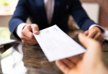 Businessperson handing over a check across a desk
