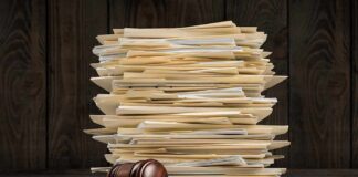 Stack of file folders with a judge's gavel on an open book
