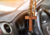 Wooden cross hanging from a car rearview mirror