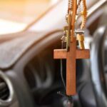 Wooden cross hanging from a car rearview mirror