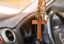Wooden cross hanging from a car rearview mirror