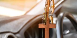 Wooden cross hanging from a car rearview mirror
