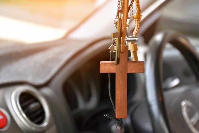 Wooden cross hanging from a car rearview mirror