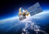 A satellite equipped with solar panels orbiting above the Earth