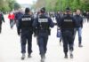 Police officers walking in a park among pedestrians
