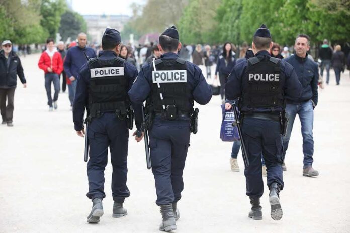 Police officers walking in a park among pedestrians
