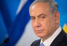 Governor Shifts Blame: Netanyahu Ouster Would ‘Help’ New York? man in suit at podium