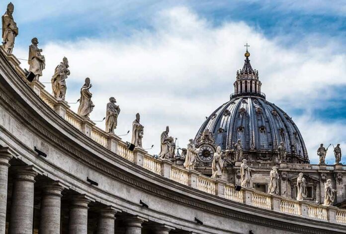 shutterstock_368201633 St. Peter's Basilica dome with statues along colonnade