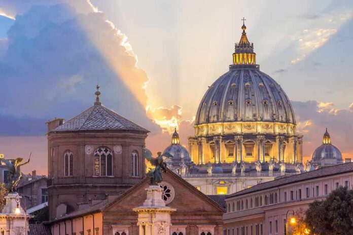 shutterstock_536262238 St. Peter's Basilica dome at sunset with glowing sky