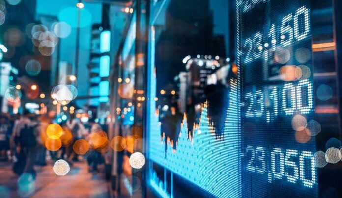 digital stock market chart on city street at night